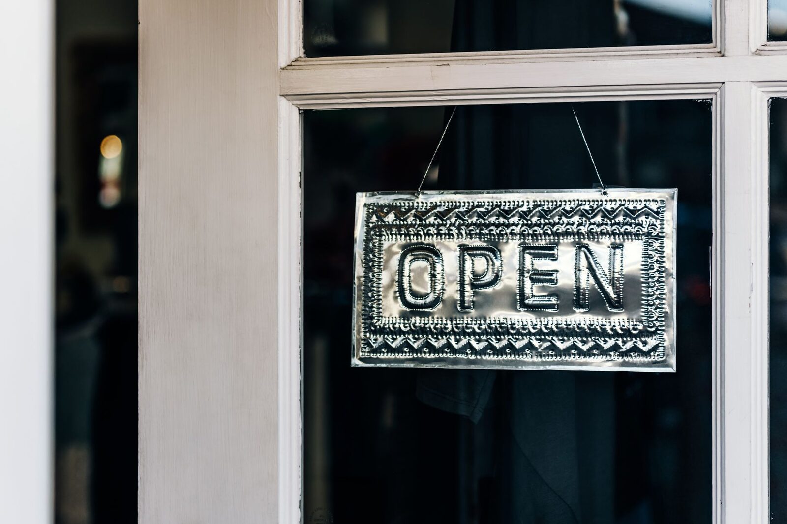 Metal open sign hanging on a shop door in Paso Robles, California.